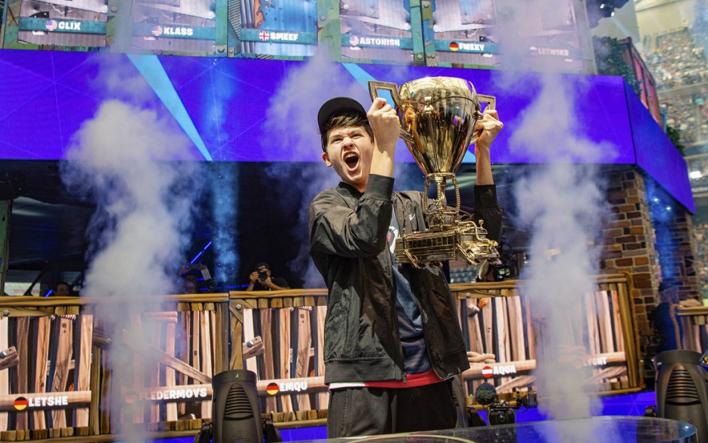 atleta de esport Bugha levantando troféu da COpa do Mundo Individual de Fortnite, a maior premiação dos esports para torneio solo de Fortnite.