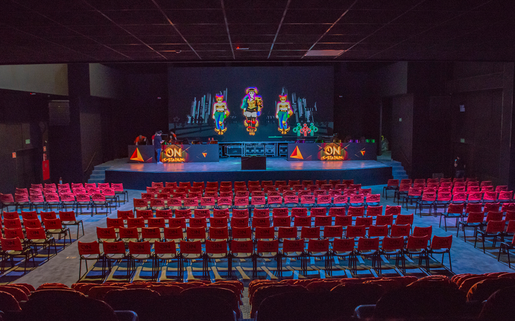 Palco com telão e cadeiras do On e-Stadium, uma das Arenas de e-sports atuais no Brasil.