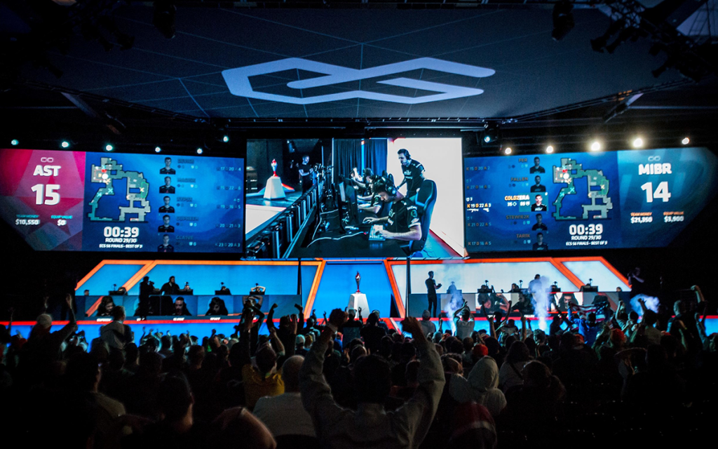 Painel com telas de duas equipes de e-sports durante campeonato na Sports Arena Arlington, uma das mais famosas arenas de e-sports.