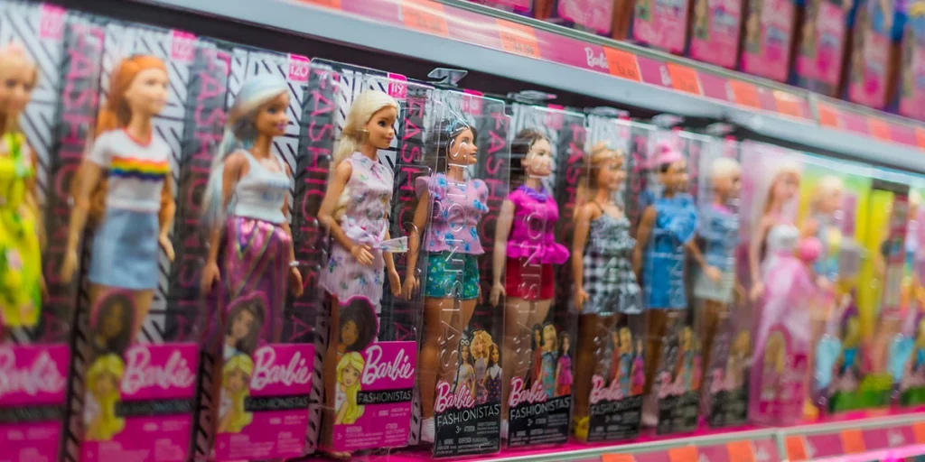 Exemplares de bonecas da Barbie enfileirados em prateleira